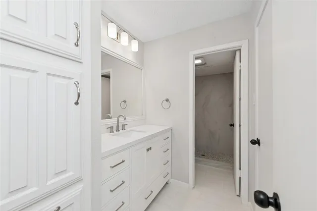a spacious bathroom with a granite countertop sink a mirror and a shower