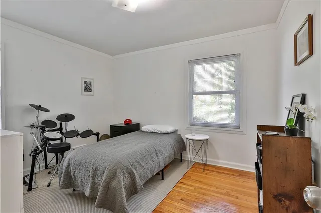 a spacious bedroom with a bed and wooden floor