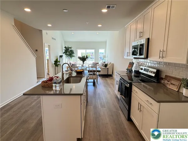 a kitchen with stainless steel appliances granite countertop a sink stove and wooden floor