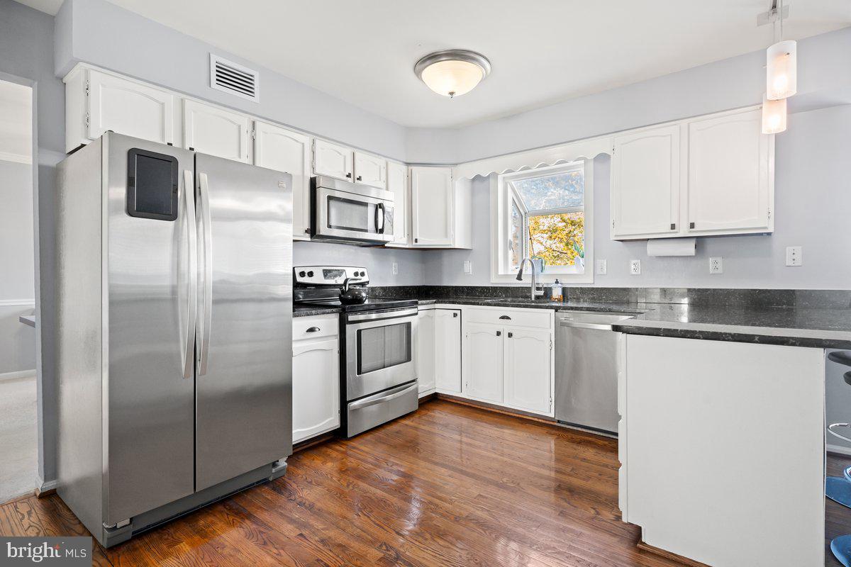 13534 King Charles Drive Chantilly, VA 20151 - Photo 11 of 28 a kitchen with a refrigerator sink and cabinets