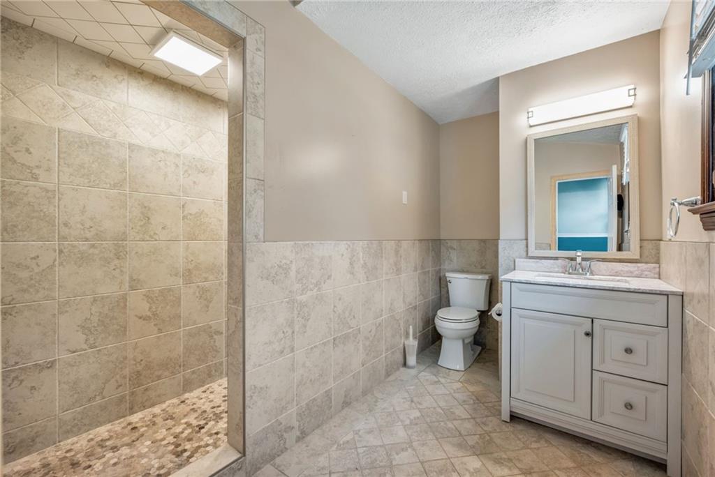 5015 Julia Lane McKees Rocks, PA 15136 - Photo 25 of 45 a bathroom with a granite countertop sink a toilet and a shower