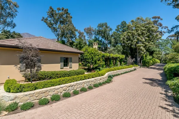 an aerial view of residential house with outdoor space and trees all around
