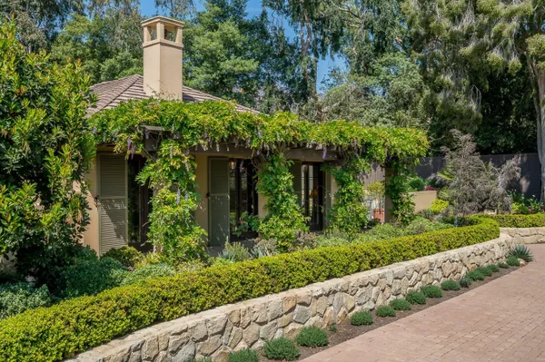a front view of a house with a yard and trees