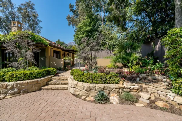 a front view of a house with a yard and potted plants