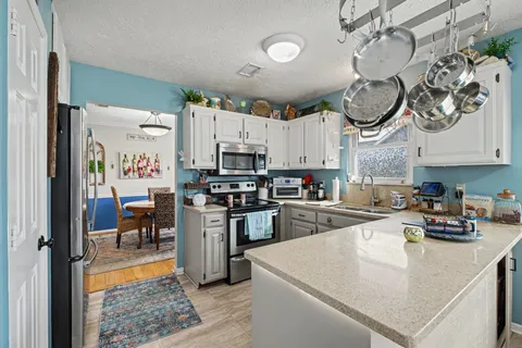 a kitchen with stainless steel appliances granite countertop a sink a stove and a refrigerator