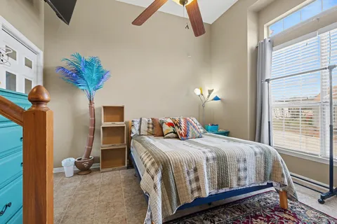 a bedroom with a bed a couch and a potted plant