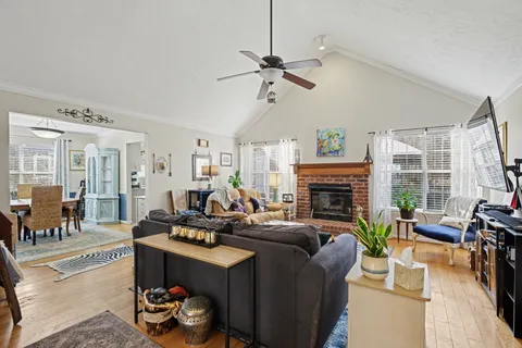 a living room with furniture fireplace and a large window