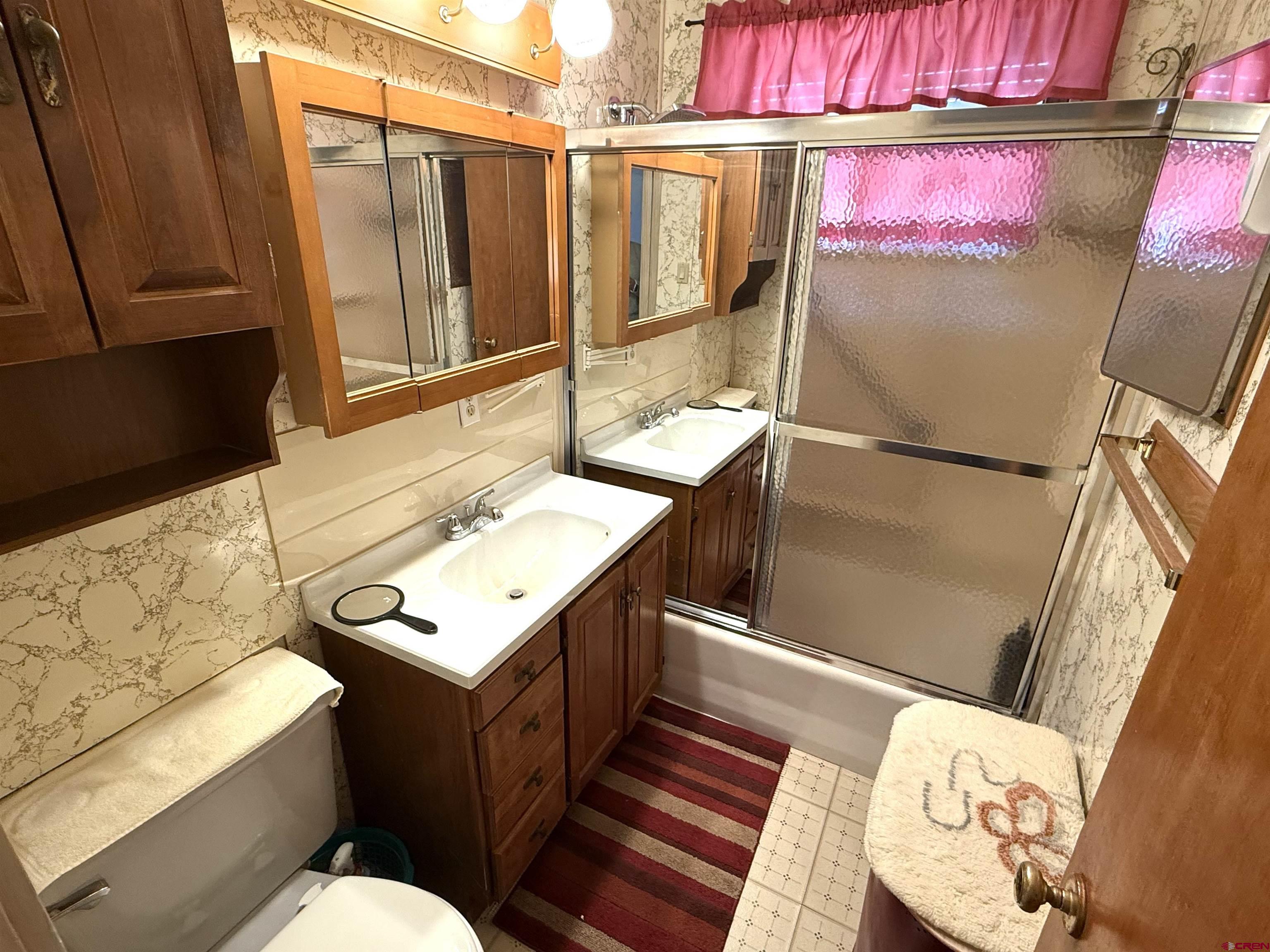 609 East 2nd Street Cortez, CO 81321 - Photo 13 of 21 a bathroom with a sink mirror vanity and toilet