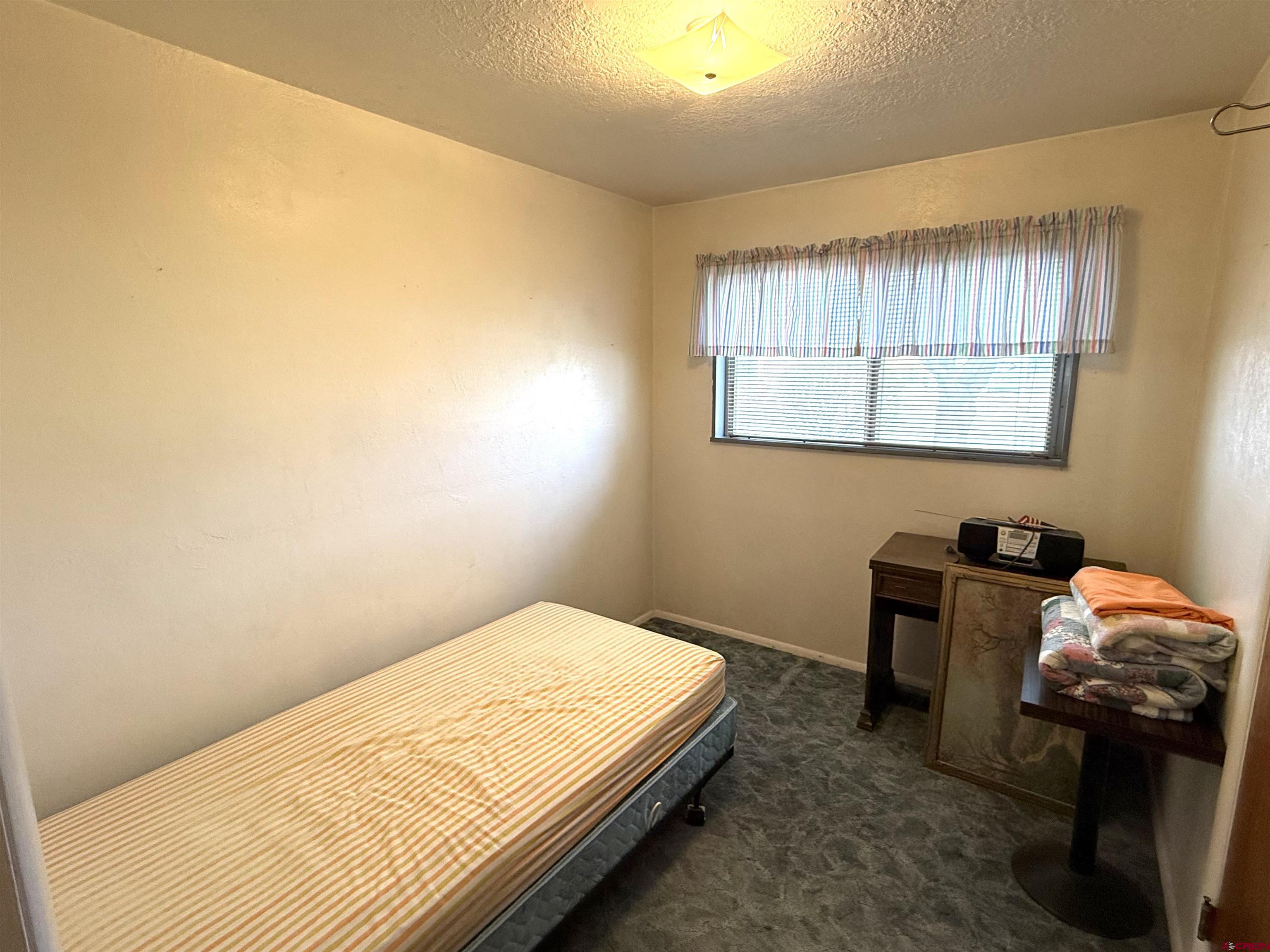 609 East 2nd Street Cortez, CO 81321 - Photo 9 of 21 a bedroom with a bed and a window