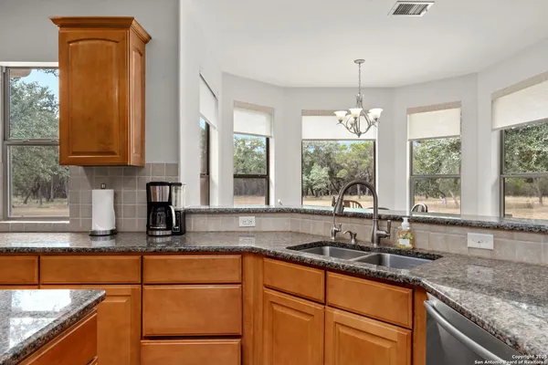 a kitchen with granite countertop a sink and a window