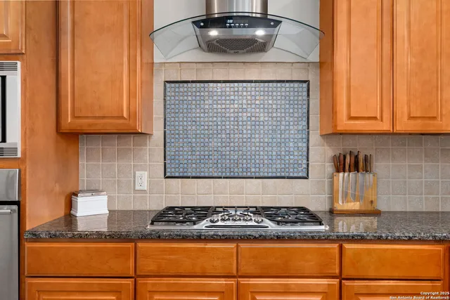 a kitchen with granite countertop a sink a stove and cabinets