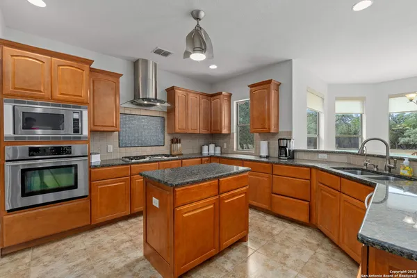 a kitchen with stainless steel appliances granite countertop a stove sink and microwave