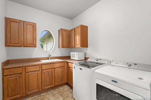 a utility room with sink dryer and washer