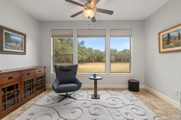a living room with furniture a flat screen tv and a window