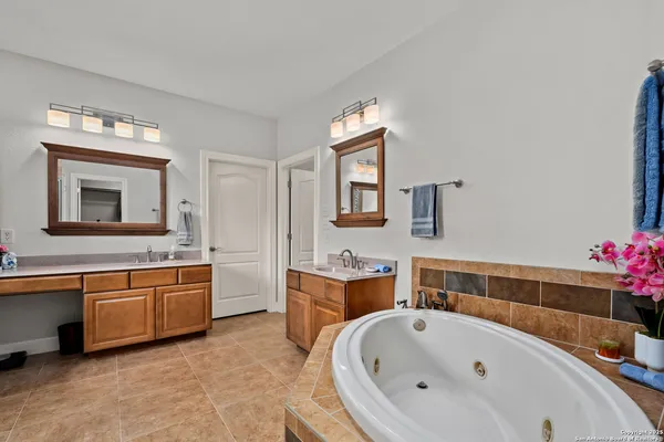 a bathroom with a tub sink and mirror