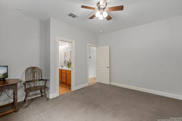 a view of a livingroom with a chandelier fan and windows