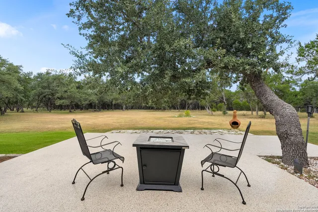 a view of a chairs and table on the patio and a lake view