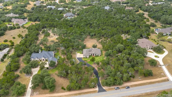 an aerial view of residential house with outdoor space and trees all around