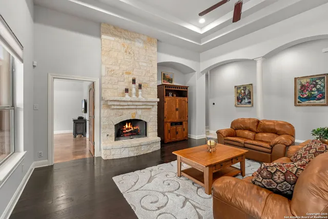 a living room with furniture a fireplace and a large window