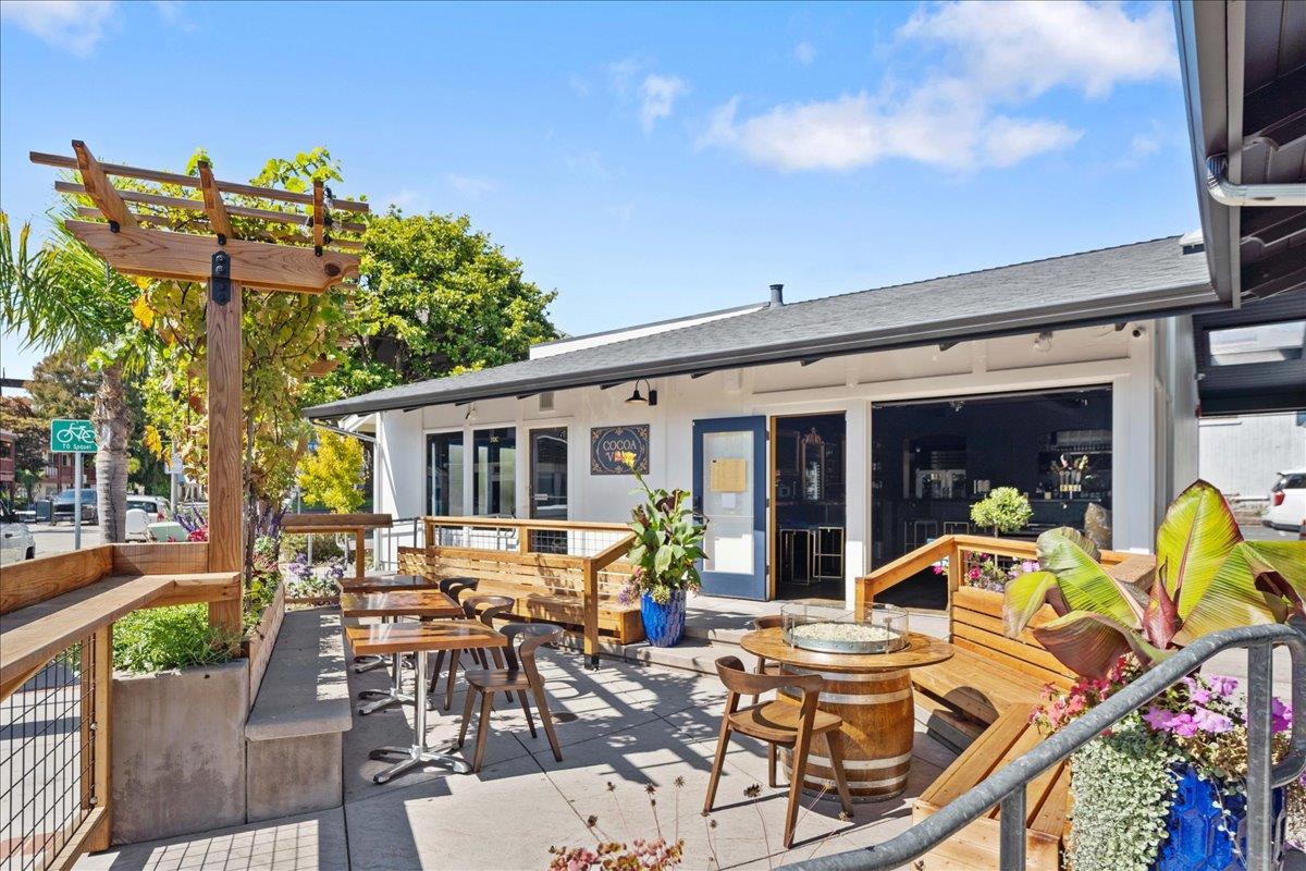 208 Stockton Avenue Capitola, CA 95010 - Photo 29 of 36 a view of a patio with table and chairs potted plants and wooden floor