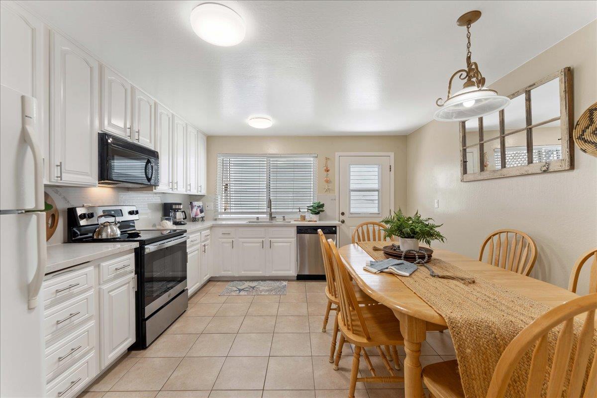 208 Stockton Avenue Capitola, CA 95010 - Photo 10 of 36 a kitchen with white cabinets and stainless steel appliances