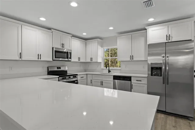 a kitchen with stainless steel appliances a refrigerator sink microwave and cabinets