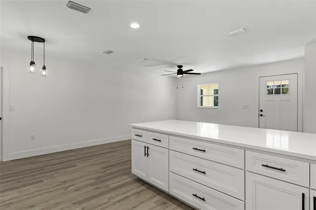 a bathroom with a granite countertop sink toilet a mirror and cabinets