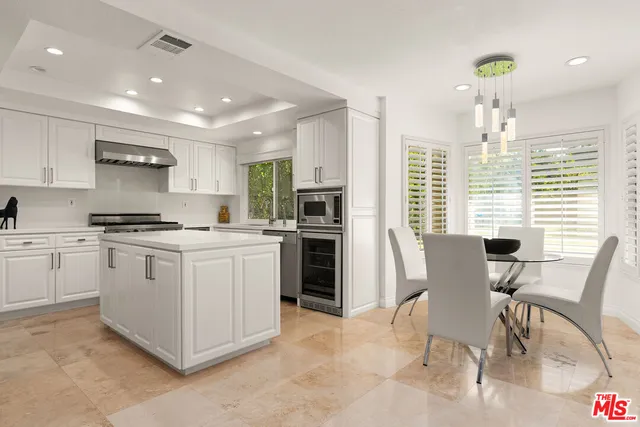 a kitchen with a white cabinets and chairs