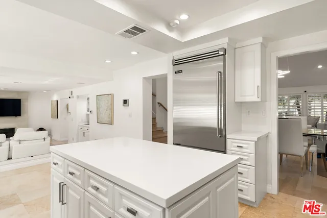 a kitchen with a refrigerator a sink and cabinets