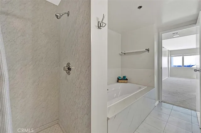 a white bath tub sitting next to a shower