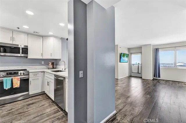 a view of a kitchen with a stove wooden cabinets and a refrigerator