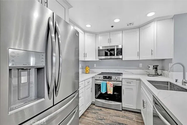 a kitchen with stainless steel appliances a refrigerator sink and microwave