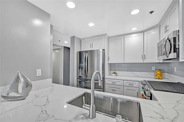 a kitchen with stainless steel appliances granite countertop a refrigerator and a stove top oven