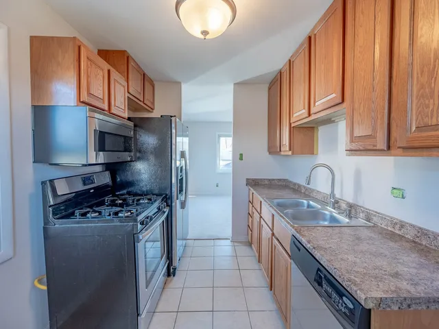 a view of a kitchen with wooden floor and electronic appliances