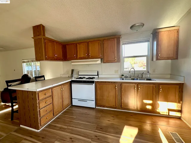a kitchen with stainless steel appliances granite countertop a sink stove and cabinets