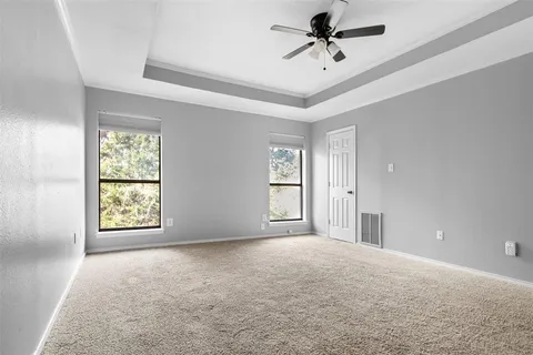 an empty room with ceiling fan and window