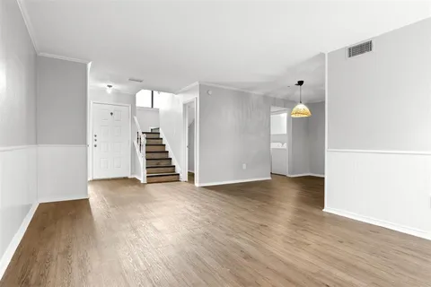 a view of a kitchen with wooden floor and a window