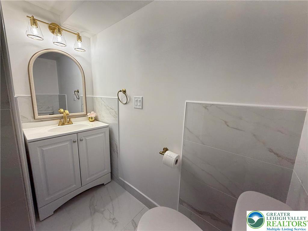 619 Hickory Street Scranton, PA 18505 - Photo 11 of 28 a bathroom with a toilet sink and mirror