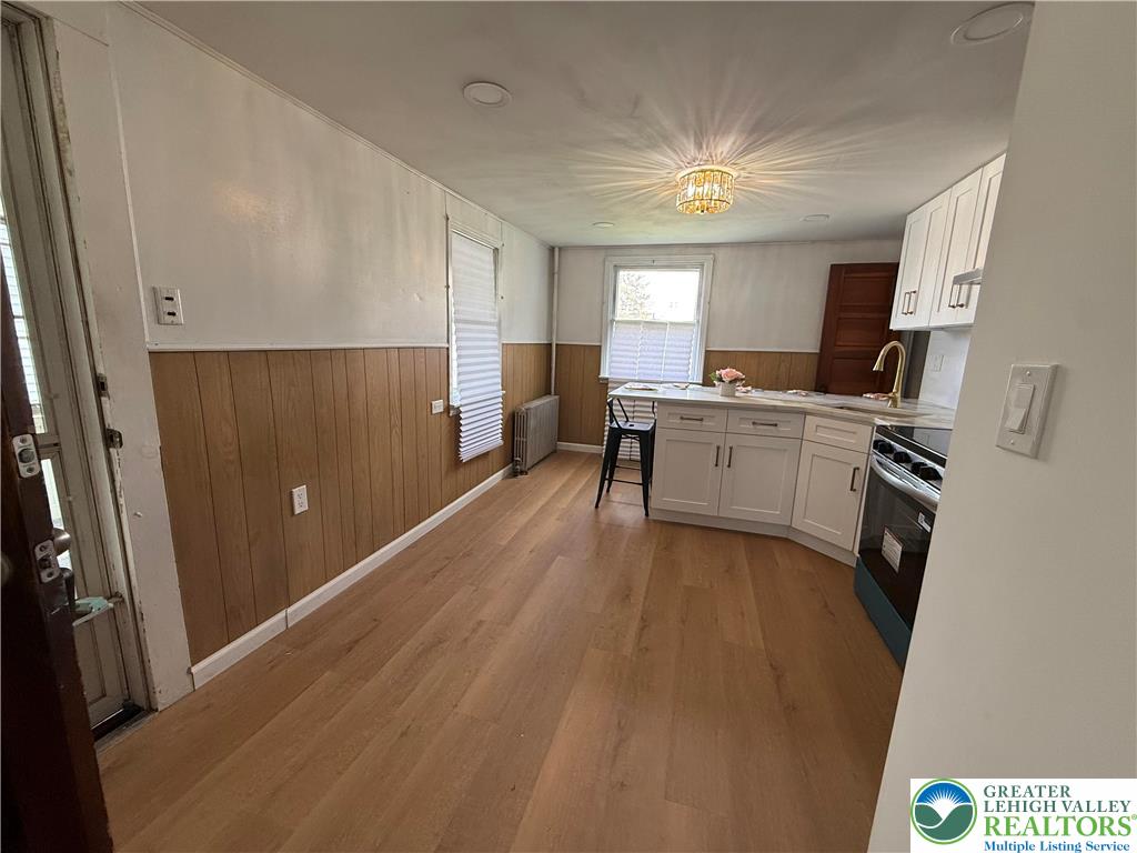 619 Hickory Street Scranton, PA 18505 - Photo 6 of 28 a kitchen with a refrigerator a sink a stove a dining table and chairs
