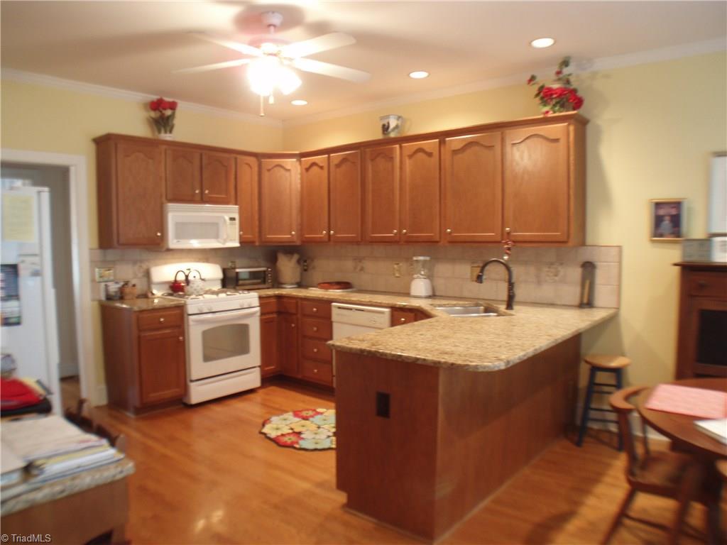 5802 Fleming Terrace Road Greensboro, NC 27410 - Photo 11 of 26 The kitchen is wonderfully designed with plenty of cabinets, granite counter tops, an eat-at bar, a pantry, and a handy desk area. The recessed lighting provides plenty of light to be creative!