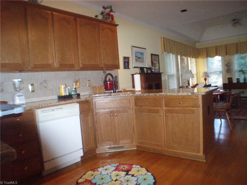 5802 Fleming Terrace Road Greensboro, NC 27410 - Photo 12 of 26 Beautiful hardwoods compliment the kitchen. Granite counter tops and tile back splash harmonize.