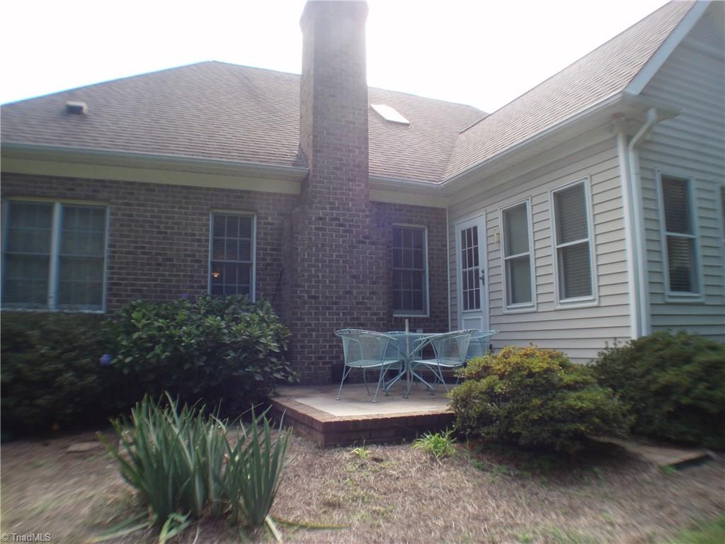 5802 Fleming Terrace Road Greensboro, NC 27410 - Photo 22 of 26 The raised patio features a connection for a gas grill and is surrounded by trees that provide privacy.