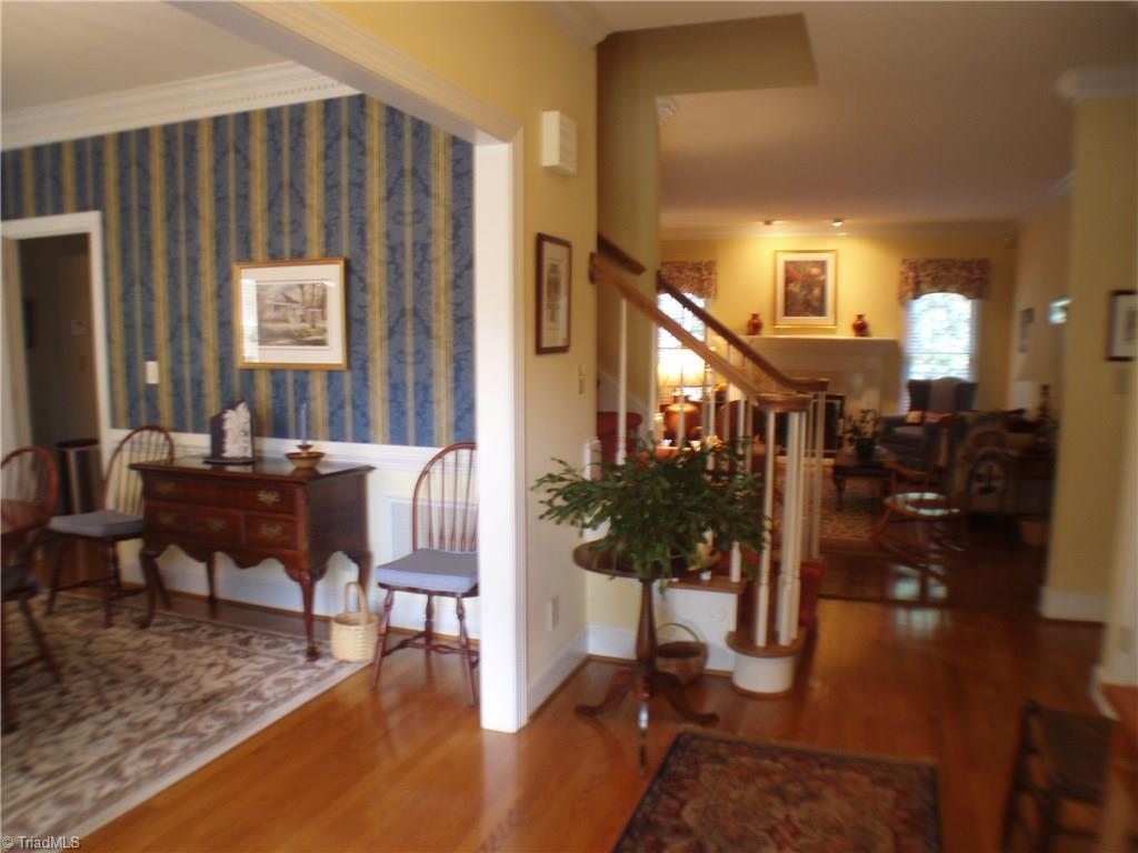 5802 Fleming Terrace Road Greensboro, NC 27410 - Photo 4 of 26 The welcoming foyer displays the beautiful hardwoods and provides a welcoming preview of this thoughtfully designed home. The stairs lead to the over 1100 sf of unfinished, floored attic space - great for storage or expansion.
