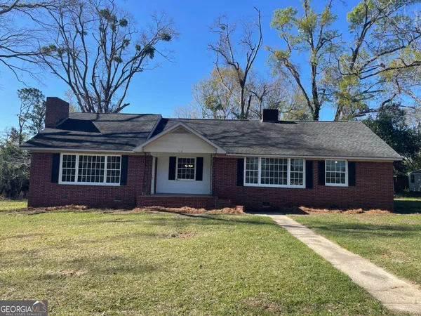 a front view of house with yard and trees