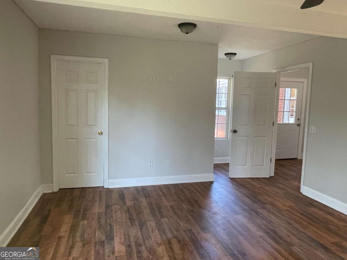 412 West 4th Street Vidalia, GA 30474 - Photo 17 of 23 an empty room with wooden floor and windows