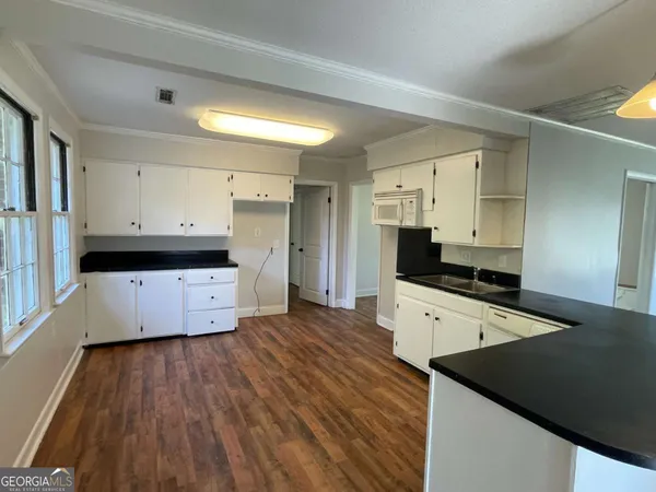 a kitchen with granite countertop a stove a sink and a refrigerator