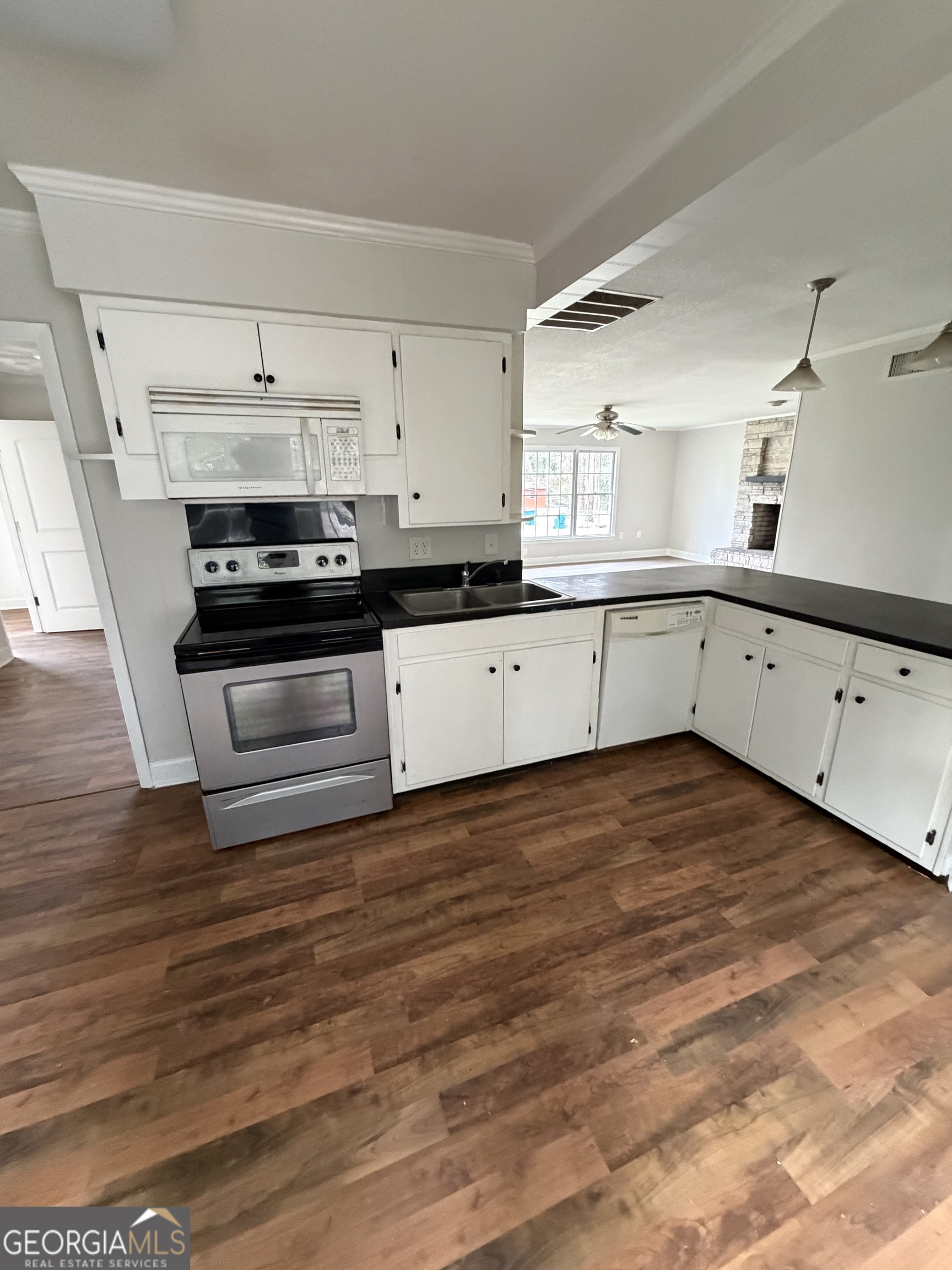 412 West 4th Street Vidalia, GA 30474 - Photo 21 of 23 a kitchen with granite countertop a stove and white cabinets