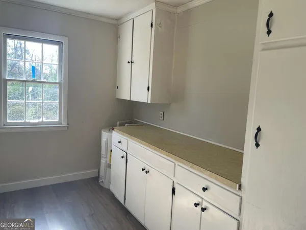 a utility room with wooden floor washer and dryer