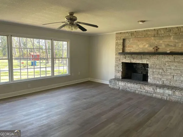 a view of an empty room with a fireplace and a window