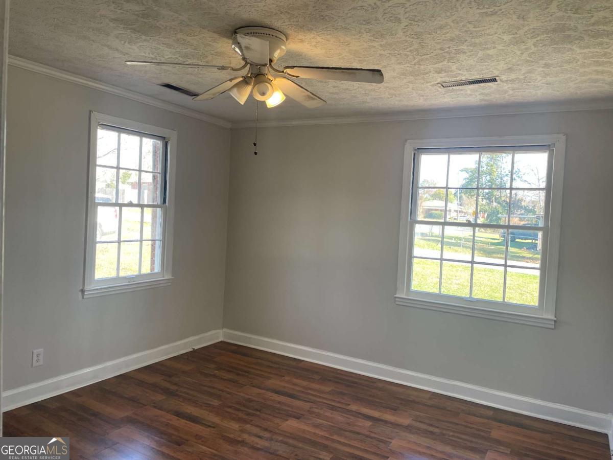 412 West 4th Street Vidalia, GA 30474 - Photo 7 of 23 a view of an empty room with wooden floor and a window